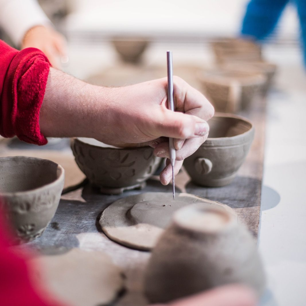 person doing clay containers
